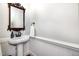 Cozy powder room with charming mirror, pedestal sink, wainscotting and updated fixtures at 4020 Gumleaf Dr, Apex, NC 27539