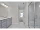 Bathroom with tiled floor, shower, gray vanity with countertop, and modern lighting at 408 Longleaf Glen Lane, Zebulon, NC 27597