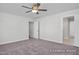 Bedroom with neutral carpet, ceiling fan, and open door to another room, with two windows with a yard view at 408 Longleaf Glen Lane, Zebulon, NC 27597