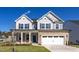Charming two-story home featuring stone accents, a two-car garage, and a well-maintained front lawn at 408 Longleaf Glen Lane, Zebulon, NC 27597
