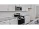 Modern kitchen featuring stainless steel appliances and gas range, bright white subway tile and marble countertops at 408 Longleaf Glen Lane, Zebulon, NC 27597