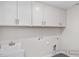Functional laundry room with white cabinets, a utility sink, and connections for a washer and dryer at 408 Longleaf Glen Lane, Zebulon, NC 27597
