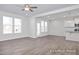 Bright living room with large windows, a back door, and an open layout connecting to the kitchen at 408 Longleaf Glen Lane, Zebulon, NC 27597