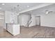 Open-concept living area with a kitchen island, modern lighting, and vinyl plank flooring throughout at 408 Longleaf Glen Lane, Zebulon, NC 27597