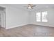 Living room with wood-look floors, two windows, and a ceiling fan at 408 Longleaf Glen Lane, Zebulon, NC 27597