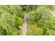 Aerial shot of the home surrounded by lush greenery, private drive, and parked cars at 4144 Fairport Rd, Kittrell, NC 27544
