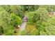 Aerial view of the home surrounded by lush greenery, private drive, and parked cars at 4144 Fairport Rd, Kittrell, NC 27544