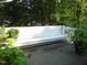 View of a deck with a white built-in bench and various potted plants and landscaping at 4144 Fairport Rd, Kittrell, NC 27544