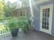Back porch features door and various plants in pots on stained porch at 4144 Fairport Rd, Kittrell, NC 27544