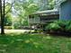 Backyard view of home with screened porch, landscaping, and rear carport at 4144 Fairport Rd, Kittrell, NC 27544