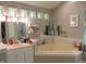 Bathroom with jacuzzi tub, vanity, and large mirrors offers plenty of natural light at 4144 Fairport Rd, Kittrell, NC 27544