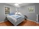 Bright bedroom featuring wood floors, two windows, and a ceiling fan at 4144 Fairport Rd, Kittrell, NC 27544