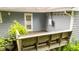 Wooden deck with an outside entry door, built-in benches, and greenery at 4144 Fairport Rd, Kittrell, NC 27544