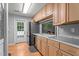 Classic kitchen with wood cabinets, stainless steel appliances, and bright light from adjacent dining area at 4144 Fairport Rd, Kittrell, NC 27544