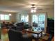 Comfortable living room featuring a sectional sofa, glass coffee table, ceiling fan, and sliding door access at 4144 Fairport Rd, Kittrell, NC 27544