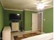 Main bedroom with green walls, tile floors and ceiling fan and dresser at 4144 Fairport Rd, Kittrell, NC 27544