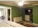 Open Main bedroom with green walls and views of the walk-in closet and television at 4144 Fairport Rd, Kittrell, NC 27544
