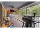 Relaxing screened porch with hanging bed, comfortable chairs, and grill at 4144 Fairport Rd, Kittrell, NC 27544