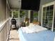 Relaxing screened-in porch with outdoor seating, a bed swing, ceiling fan, and a mounted TV at 4144 Fairport Rd, Kittrell, NC 27544