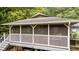 View of the back screened porch featuring white railings, screened walls, and a bench swing at 4144 Fairport Rd, Kittrell, NC 27544