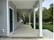 Covered front porch of a home, featuring support columns and a view of the front yard at 431 Mayview Dr, Creedmoor, NC 27522