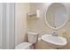 Cozy bathroom features a pedestal sink, mirror, and toilet at 4705 Walden Pond Dr # 110-C, Raleigh, NC 27604