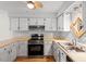 Charming kitchen features painted cabinets, stainless appliances, and ceiling fan at 4705 Walden Pond Dr # 110-C, Raleigh, NC 27604