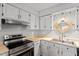 Charming kitchen features painted cabinets, stainless appliances, and double sink at 4705 Walden Pond Dr # 110-C, Raleigh, NC 27604