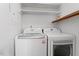 Functional laundry area featuring a washer, dryer, and handy shelving for efficient organization at 4705 Walden Pond Dr # 110-C, Raleigh, NC 27604