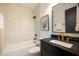 Charming bathroom featuring a black marble vanity, gold accents, and tub with tile surround at 500 Grigsby Ave, Holly Springs, NC 27540