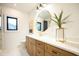 Well-lit bathroom featuring a modern vanity with marble top, gold fixtures, and round mirror at 500 Grigsby Ave, Holly Springs, NC 27540