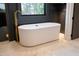 Contemporary bathroom features a standalone tub with gold faucet and marble tile flooring at 500 Grigsby Ave, Holly Springs, NC 27540