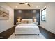 Serene bedroom features a large bed with gray accent wall, wood floors, and a modern ceiling fan at 500 Grigsby Ave, Holly Springs, NC 27540
