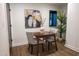 Charming dining area with a wooden table, two chairs, and a modern art piece enhancing the cozy atmosphere at 500 Grigsby Ave, Holly Springs, NC 27540
