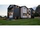Modern home featuring a striking dark and light exterior, professional landscaping, and outdoor lighting at 500 Grigsby Ave, Holly Springs, NC 27540