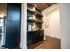 Inviting hallway featuring dark cabinetry, floating shelves and rich hardwood floors at 500 Grigsby Ave, Holly Springs, NC 27540