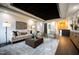 Stately living room featuring dark wood floors, tray ceiling with decorative inlays, and fireplace at 500 Grigsby Ave, Holly Springs, NC 27540