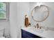Modern powder room with blue vanity, round mirror, and quartz countertop at 500 Spruce St, Durham, NC 27703