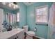 Bright bathroom with turquoise walls, a vanity, and shower-tub combo at 5316 Tanglewood Pine Ln, Raleigh, NC 27610