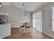 Sunlit dining area featuring wood flooring, a modern light fixture, and window with blinds at 5316 Tanglewood Pine Ln, Raleigh, NC 27610