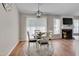Bright dining area features a modern light fixture, four chairs, and view to the fireplace at 5316 Tanglewood Pine Ln, Raleigh, NC 27610