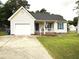 Charming single-story home featuring a front porch, attached garage, and well-maintained lawn at 5316 Tanglewood Pine Ln, Raleigh, NC 27610