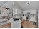 Open kitchen boasts white cabinets, stainless steel appliances, quartz counters, and hardwood floors at 5316 Tanglewood Pine Ln, Raleigh, NC 27610