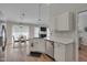 Open kitchen and dining area feature white cabinets, quartz counters, and hardwood floors at 5316 Tanglewood Pine Ln, Raleigh, NC 27610