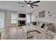 Well-lit living room featuring a modern fireplace, comfortable seating, and a stylish ceiling fan at 5316 Tanglewood Pine Ln, Raleigh, NC 27610