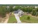Aerial view of home with a large driveway, fenced yard, and wooded surroundings at 576 Prairie Ln, Lillington, NC 27546