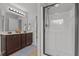 Bright bathroom with double vanity, wood cabinets, and a glass enclosed walk-in shower at 576 Prairie Ln, Lillington, NC 27546