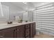 Bathroom with a double vanity, dark wood cabinets, and a shower with a striped curtain at 576 Prairie Ln, Lillington, NC 27546