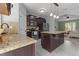 Open kitchen with stainless steel appliances, a granite island, and views into the adjoining living area at 576 Prairie Ln, Lillington, NC 27546