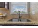 Close-up of a stainless steel kitchen sink with granite countertops and tile backsplash at 576 Prairie Ln, Lillington, NC 27546